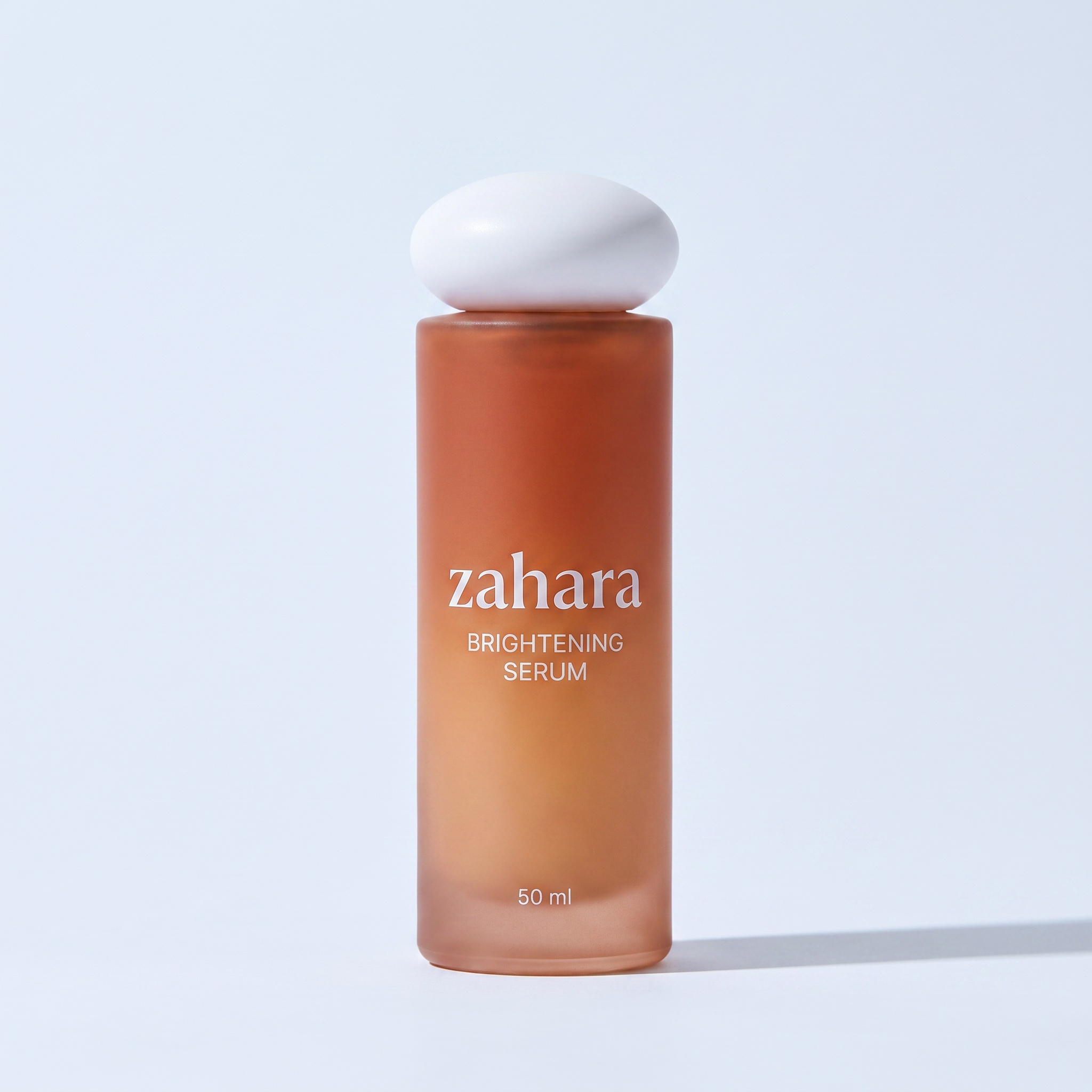 Zahara Brightening Serum packshot: amber-to-terracotta gradient bottle with the white pebble cap.