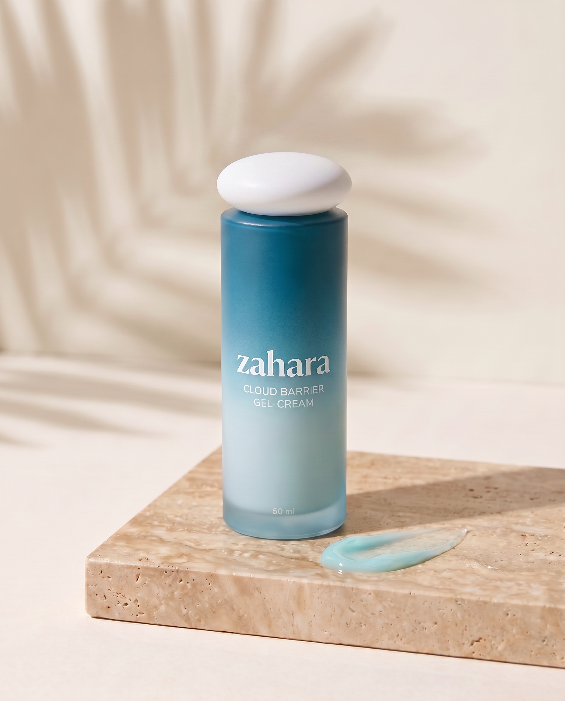 Zahara Cloud Barrier Gel-Cream bottle on wet travertine stone beside an aqua gel smear, with soft tropical leaf shadows.